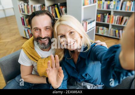 Freundliche, reife Geschäftsleute, die eine Pause von der Arbeit machen und ein Selfie machen. Glückliche erfolgreiche Mitarbeiter in stilvoller Kleidung, die direkt auf die Kamera blicken, lächelnd, partnerschaftliches Konzept Stockfoto