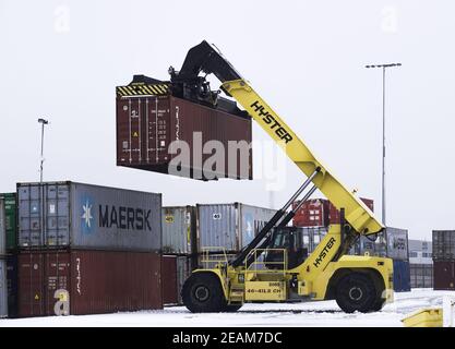 DONCASTER, GROSSBRITANNIEN - 2. FEBRUAR 2021. Eine schwere Hubmaschine, die einen Frachtkasten oder einen Transportbehälter in einem Bahnterminal oder Hof hebt, Stockfoto