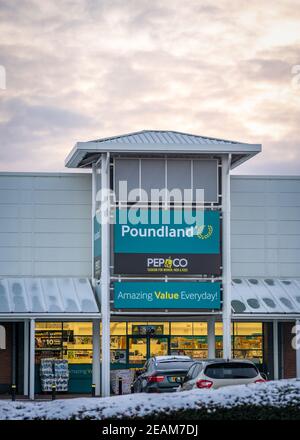 Mansfield, Nottingham UK Poundland Company Group Ltd Einzelhandelsgeschäft Vorderseite mit Logo-Schild und hell bewölkt orange Himmel bei Sonnenuntergang Stockfoto