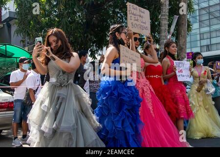 Demonstranten, die Hochzeitskleider tragen, marschieren während der Demonstration mit Plakaten auf die Straße. Tausende Menschen gingen am fünften Tag der Proteste gegen den Militärputsch auf die Straßen von Yangon und forderten die Freilassung von Aung San Suu Kyi. Das Militär von Myanmar nahm am 01. Februar 2021 die Staatsrätin von Myanmar, Aung San Suu Kyi, fest und erklärte den Ausnahmezustand, während sie die Macht im Land für ein Jahr ergattete, nachdem sie die Wahl gegen die Nationale Liga für Demokratie (NLD) verloren hatte. Stockfoto