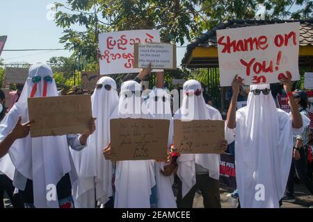 Demonstranten in Geisterkostümen zeigen Plakate während der Demonstration. Tausende Menschen gingen am fünften Tag des Protests gegen den Militärputsch auf die Straßen von Yangon und forderten die Freilassung von Aung San Suu Kyi. Das Militär von Myanmar nahm am 01. Februar 2021 die staatliche Beraterin von Myanmar Aung San Suu Kyi fest und erklärte den Ausnahmezustand, während sie die Macht im Land für ein Jahr ergattete, nachdem sie die Wahl gegen die National League for Democracy (NLD) verloren hatte. Stockfoto