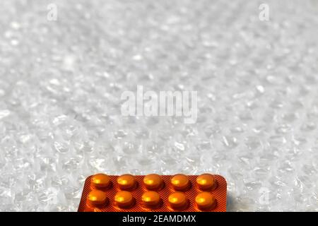 Trendy modernen minimalistischen Hintergrund der orangen Pillen Blister. Bubble Bag Hintergrund. Pakete von Tabletten in Blasen sind horizontal angeordnet. Rahmen Stockfoto