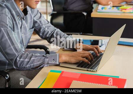 Junger schöner Mann mit Laptop am Arbeitsplatz Stockfoto