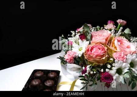 Blumen und Schokolade. Blumen, Brautstrauß Nahaufnahme. Dekoration von Rosen, Pfingstrosen und Zierpflanzen. Geschenk für Valentinstag Frauentag Stockfoto