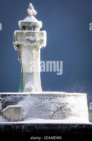 Sassnitz, Deutschland. Februar 2021, 10th. Der eisige Leuchtturm am Pier der Hafeneinfahrt. Frostiges Wetter und Schneefall behindern den Verkehr in Norddeutschland. Quelle: Jens Büttner/dpa-Zentralbild/dpa/Alamy Live News Stockfoto