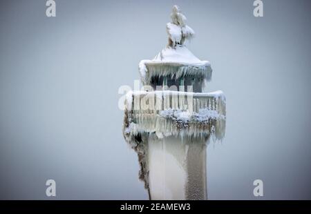 Sassnitz, Deutschland. Februar 2021, 10th. Die eisige Spitze des Leuchtturms am Pier des Hafeneingangs. Eisige Witterung und Schneefall behindern den Verkehr in Norddeutschland. Quelle: Jens Büttner/dpa-Zentralbild/dpa/Alamy Live News Stockfoto