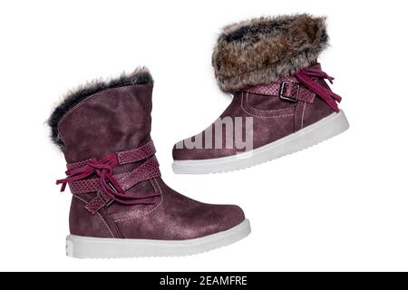 Kinder Winterstiefel. Nahaufnahme eines Paares elegante violette Wildleder Winterstiefel und gefüttert mit braunem Fell. Mädchen Winterschuh Mode neue Trends isoliert auf einem weißen Hintergrund. Makrofotografie. Stockfoto