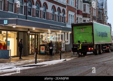Lieferung von Lebensmitteln in den frühen Morgenstunden für Co-op-Supermarkt in Hamlet Court Road, Westcliff on Sea, Essex, UK, mit Schnee von Storm Darcy. Vereiste Straße Stockfoto