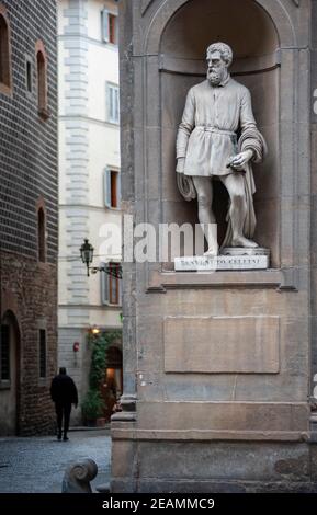 Florenz, Italien - 2021, Januar 31: Blick auf die Stadt, in der Nähe der Uffizien Museumshof. Benvenuto Cellini Statue im Vordergrund. Ein Mann zu Fuß tun Stockfoto