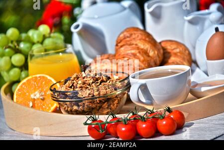 Frühstück serviert mit Kaffee, Saft, Croissants und Obst Stockfoto