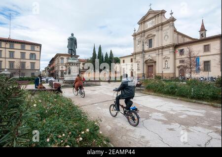 Florenz, Italien - 2021. Januar 31: Piazza San Marco mit seiner Barockkirche. Menschen auf Fahrrädern. Stockfoto