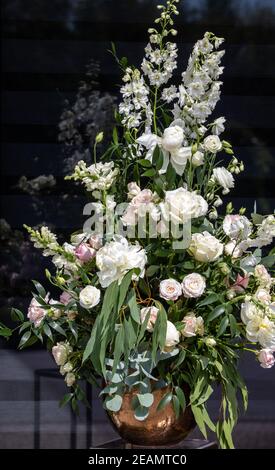 Beeindruckendes floristisches Bouquet von weißen Rosen und Delphinium - grün Drehen Stockfoto