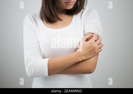 Frau Kratzer auf ihren Arm. Stockfoto