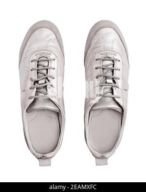Silberne Leder Sneakers weißen Hintergrund isoliert Nahaufnahme von oben, stilvolle hellgraue Wildleder Gummischuhe, Paar beige Schuhe mit Schnürsenkeln, Sitzstiefel Stockfoto