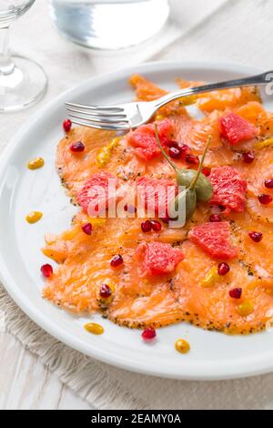 Lachs-Carpaccio mit rosa Grapefruit und Granatapfel Stockfoto