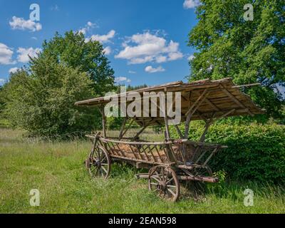 Ein alter Heuwagen mit Holzrädern und Holzdach Stockfoto