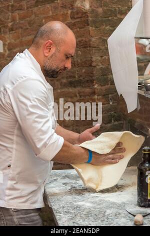 Ein Mann, der Pizza von Hand macht, indem er den Teig durchgeht Bologna Italien Stockfoto