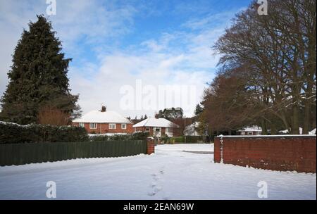 Ein helllichter Himmel nach Schneefall in einem Wohngebiet von Hellesdon, Norfolk, England, Großbritannien. Stockfoto