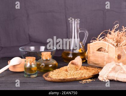 Olivenöl und Sesamsamen auf Holzoberfläche Stockfoto