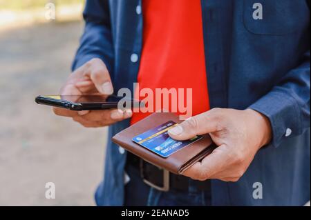 Ein Mann mit Telefon, Kreditkarte und Geldbörse Stockfoto