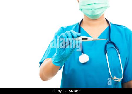 Frau Arzt in blauer Uniform hält digitales Thermometer Stockfoto