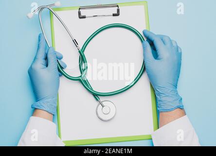 Ärztin Hände in blauen Latexhandschuhen hält ein Metall Stethoskop Stockfoto