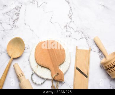 Küchengeräte aus Holz auf weißem Marmortisch, Blick von oben Stockfoto