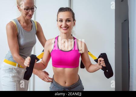 Frau mit Sling Trainer während physikalische Therapie aus einer Schädigung zu erholen Stockfoto