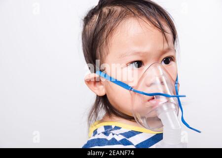 Nahaufnahme Asian Gesicht, kleine Baby Mädchen krank sie mit Dampf Inhalator Vernebler Maske Inhalation sich Stockfoto