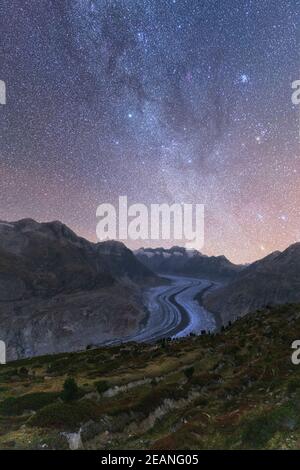 Leuchtende Sterne und Milchstraße am Nachthimmel über dem Aletschgletscher, den Berner Alpen, dem Kanton Wallis, der Schweiz, Europa Stockfoto