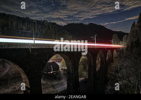 Hochgeschwindigkeitsaufnahme eines Zuges, der an einer Brücke in der Nähe von Blackforest, Deutschland, vorbeifährt Stockfoto