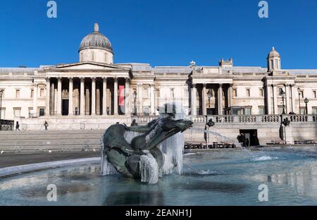 London, Großbritannien. Februar 2021, 10th. Das am 10. Februar 2021 aufgenommene Foto zeigt Eiszapfen um Skulpturen am Brunnen am Trafalgar Square in London, Großbritannien. Storm Darcy hat in London seit mehreren Tagen Schnee gebracht. Quelle: Han Yan/Xinhua/Alamy Live News Stockfoto