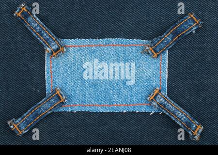 Rahmen aus Denim mit vier Trägern von Jeans, liegt auf dem dunklen Denim Stockfoto