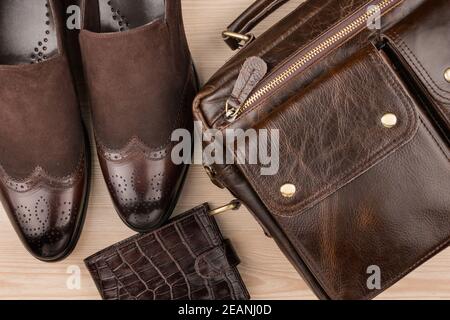 Klassische braune Schuhe, Aktentasche und Geldbörse auf dem Holzboden Stockfoto