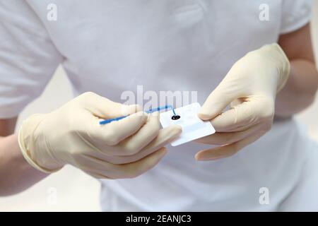 Der Zahnarzt hält in den Händen ein Kontrastgel für die professionelle Hygiene der Mundhöhle. Prävention von Karies und Zahnfleischerkrankungen. Konzept des Gesundheitsschutzes. Stockfoto