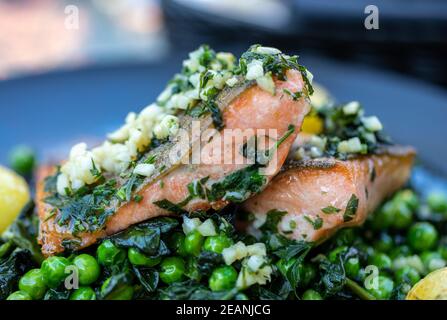 Lachsfilet mit grünen Erbsen und Spinat Stockfoto