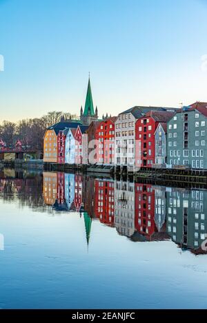 Sonnenuntergang Blick auf die Kathedrale von Nidaros und bunte Holzhäuser rund um den Fluss Nidelva im Stadtteil Brygge von Trondheim, Norwegen Stockfoto