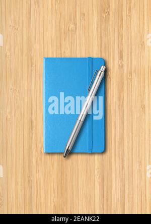 Blaues geschlossenes Notizbuch mit einem Stift auf Holzhintergrund Stockfoto