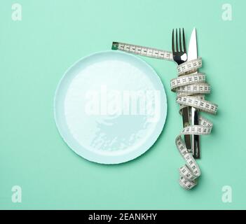 Leere runde Platte und Gabel und Messer in weiß gewickelt Maßband Stockfoto