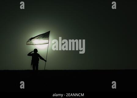 Silhouette von salutieren US-Armee Soldat mit Flagge Stockfoto