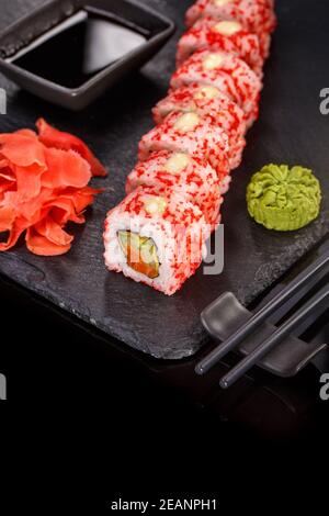 Sushi mit Essstäbchen, Ingwer, Sojasauce und Wasabi. Japanisches Essen. Set Sushi-Rolle mit Gemüse, Fisch und Kaviar. Stockfoto