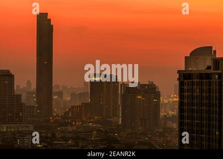 Luftverschmutzung in Bangkok, Thailand. Smog und Feinstaub von PM2,5 bedeckten Stadt am Morgen mit orangefarbenem Sonnenaufgangshimmel. Stadtbild mit verschmutzter Luft. Schmutzige Umgebung. Giftiger Staub in der Stadt. Ungesunde Luft. Stockfoto