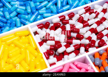 Draufsicht auf bunte Kapsel Pillen in Kunststoff-Tablett. Pharmaindustrie. Gesundheitswesen und Medizin. Pharmazeutik-Konzept. Vitamine und Nahrungsergänzungsmittel Kapsel. Full Frame von hellen Farbe Kapsel Pillen. Stockfoto