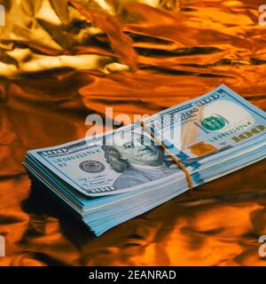 Ein großer Dollar-Wad auf goldenem Hintergrund. Stockfoto