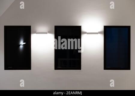 Drei Fenster und Lichter an einer weißen Wand eines Gebäude Stockfoto