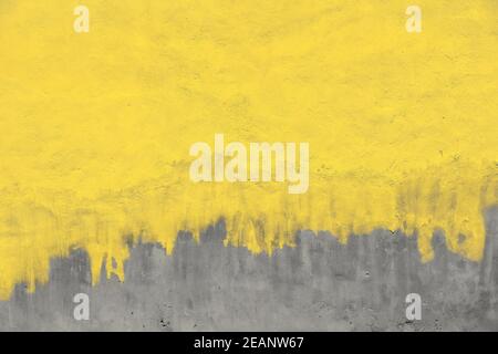 Verwitterte gelb lackierte graue Betonwand Stockfoto