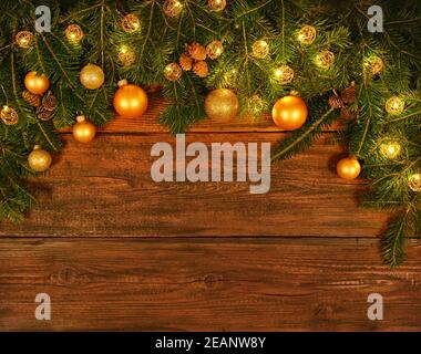 Weihnachtsbaum mit Lichtern und Kugeln über Holz Stockfoto