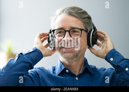 Lächelnd Ältere Senior Listening Music Stockfoto