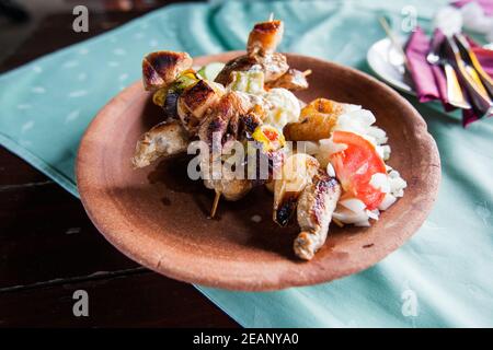 Spieße mit Fleisch, serviert mit Zwiebeln auf dem Restauranttisch Stockfoto