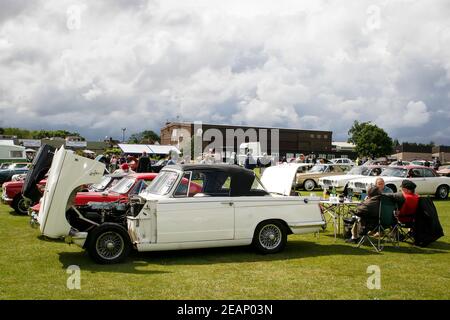 Autoliebhaber, die eine Auswahl an Oldtimern und Retro-Autos auf einer Oldtimer-Ausstellung in Großbritannien sehen Stockfoto